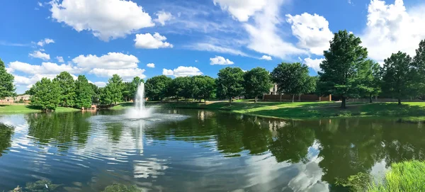 Panoramic view pond with water fountain in small American neighborhood — Stock Photo, Image