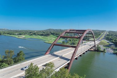 Pennybacker Bridge over Colorado river and Hill Country landscape in Austin clipart