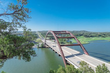 Pennybacker Bridge over Colorado river and Hill Country landscape in Austin clipart