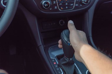 Modern bir arabanın otomatik vites çubuğu tutan erkek el