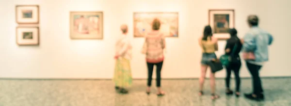 Panorama ver borrosa gente de fondo mirando la exhibición de bellas artes en el museo en EE.UU. — Foto de Stock
