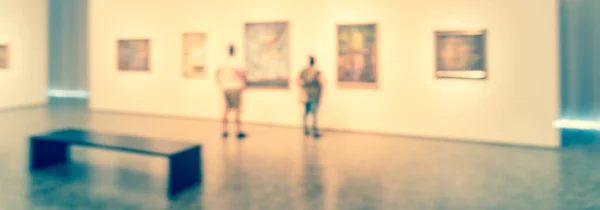 Panorama view blurry background people looking at fine art display at museum in USA — Stock Photo, Image