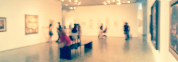 Panorama view blurry background people looking at fine art display at museum in USA — Stock Photo, Image