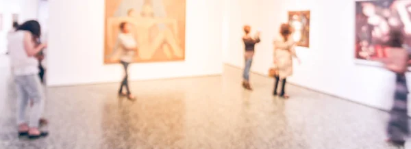 Panorama view blurry background people looking at fine art display at museum in USA — Stock Photo, Image