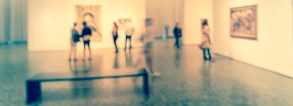 Panorama view blurry background people looking at fine art display at museum in USA — Stock Photo, Image