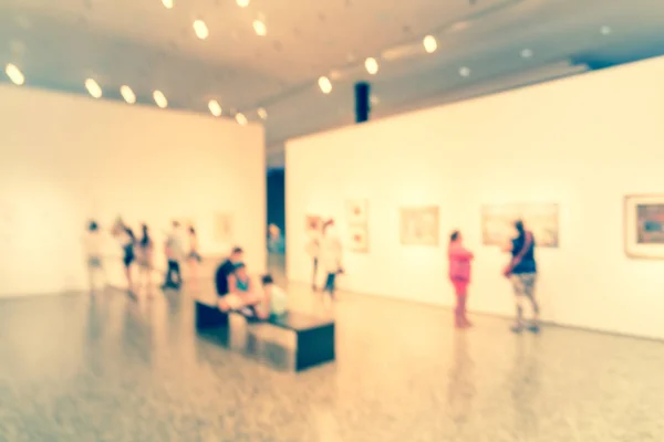 Gente de fondo borrosa mirando exhibición de bellas artes en el museo en América — Foto de Stock