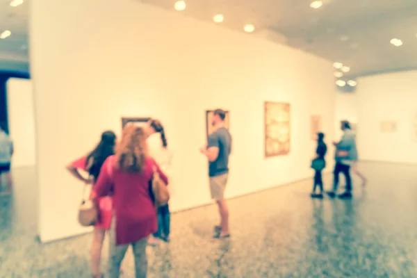 Gente de fondo borrosa mirando exhibición de bellas artes en el museo en América — Foto de Stock