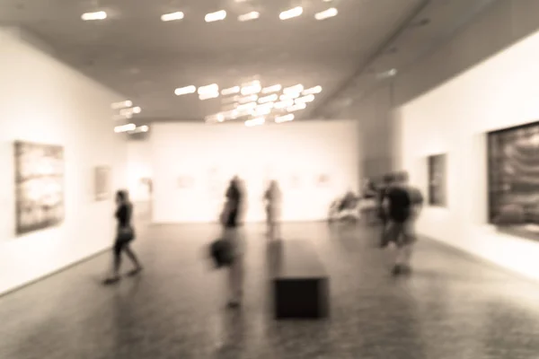 Filtered image blurry background people looking at fine art display at museum in USA — Stock Photo, Image