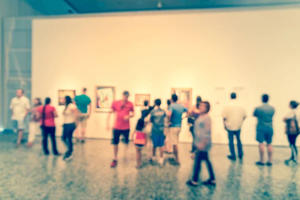 Blurry background people looking at fine art display at museum in America — Stock Photo, Image