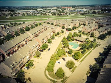 Karayolu ve alışveriş caddeleri yakınında yüzme havuzu ile havadan görünüm apartman