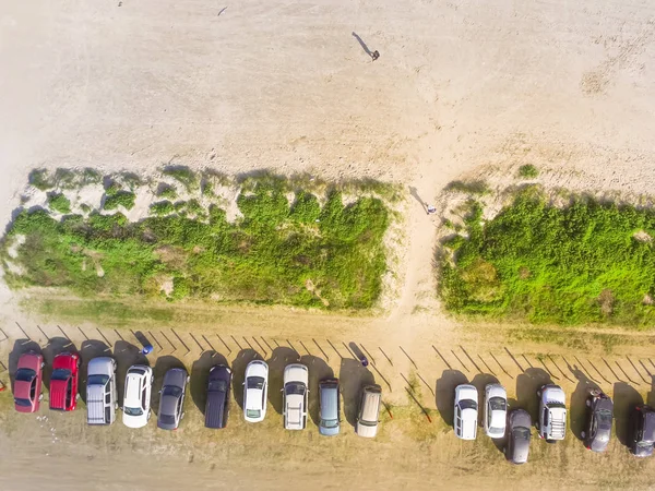 Aerial view busy sandy parking lot along shoreline of Galveston beach, Texas