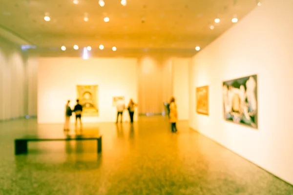 Filtered image blurry background people looking at fine art display at museum in USA — Stock Photo, Image