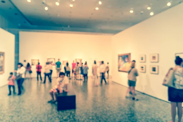 Vintage tone blurred image people visiting art exhibition in US. Generic background of fine art gallery abstract defocused blur. — Stock Photo, Image