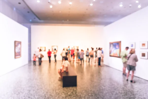 Gente de fondo borrosa mirando exhibición de bellas artes en el museo en América — Foto de Stock