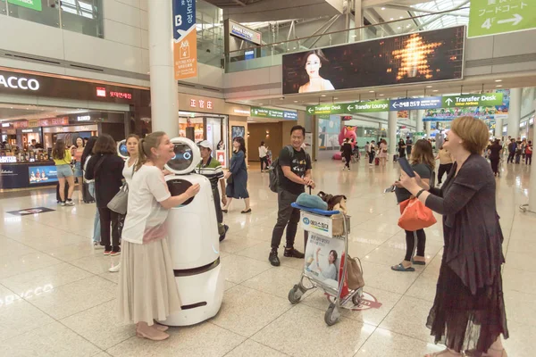 Passageiros tirando fotos com o AIRSTAR Passenger Aiding Robot no aeroporto de Incheon, na Coreia do Sul — Fotografia de Stock