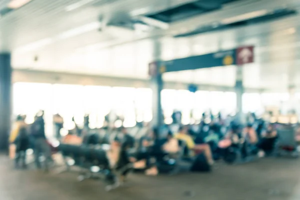 Fondo borroso diversos viajeros esperando en el aeropuerto a bordo de la puerta — Foto de Stock