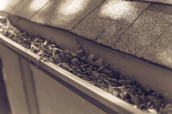 Gefilterte Bildrinne, die durch getrocknete Blätter und unordentlichen Schmutz verstopft ist, muss aufgeräumt werden — Stockfoto