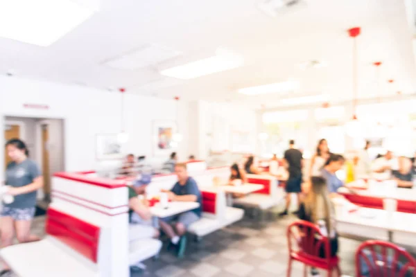 Blurry background typical American fast food restaurant with customer dining in
