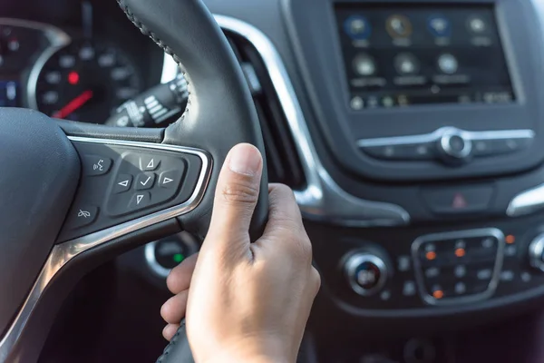 Asian man hand holding steering wheel with audio control and call buttons — Stock Photo, Image