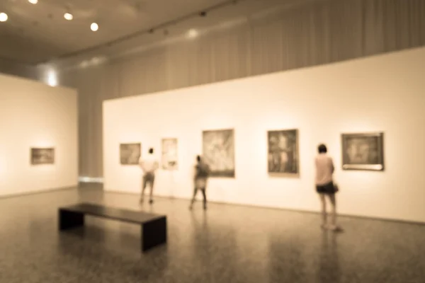 Vintage tone blurred image people visiting art exhibition in US. Generic background of fine art gallery abstract defocused blur. — Stock Photo, Image