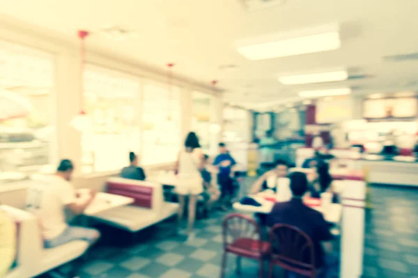 Filtered image blurry background typical American fast food restaurant with customer
