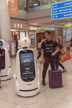 Passengers taking photo with AIRSTAR Passenger Aiding Robot at Incheon airport in South Korea clipart