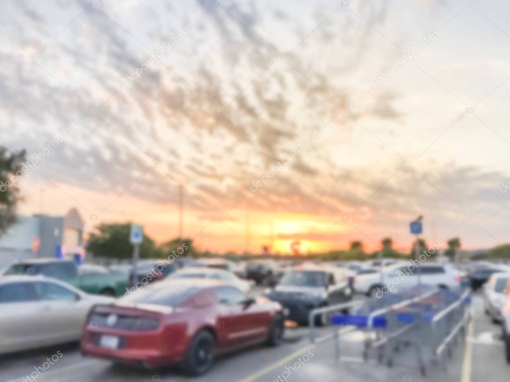 Blurry background parking garage with return shopping carts under sunset cloud near Dallas