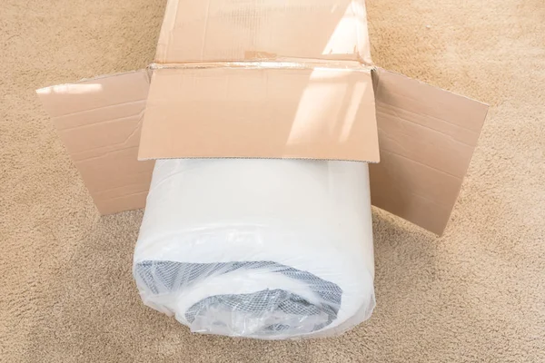 Close-up top view roll-packed spring mattresses unbox on carpet floor background — Stock Photo, Image