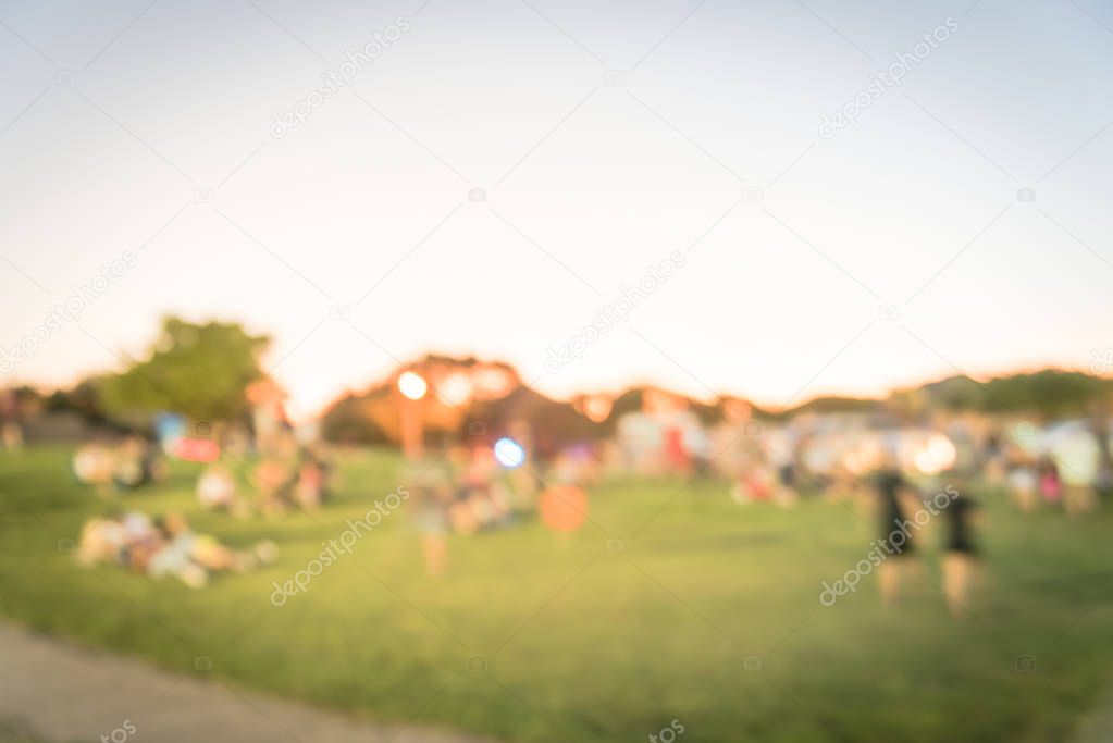 Blurry background diverse multicultural people at summer event on park grass lawn near Dallas