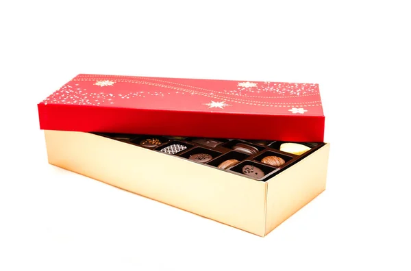 Caja de chocolate parcialmente abierta con tapa roja festiva y surtido de trufas —  Fotos de Stock