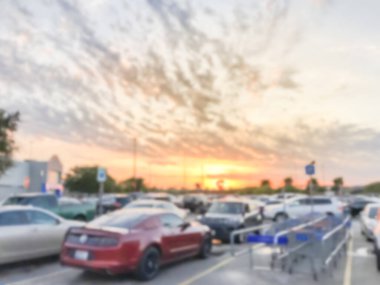 Dallas yakınlarındaki günbatımı bulutu altında dönüş alışveriş arabaları ile bulanık arka plan otopark
