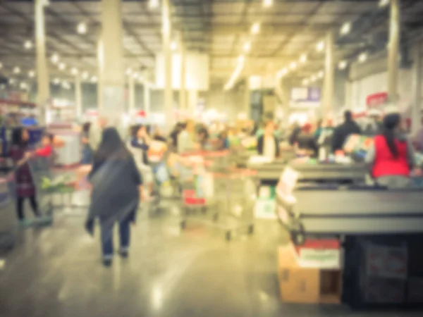 Fundo desfocado há muito tempo diversas pessoas em fila no balcão de check-out da loja por atacado nos EUA — Fotografia de Stock