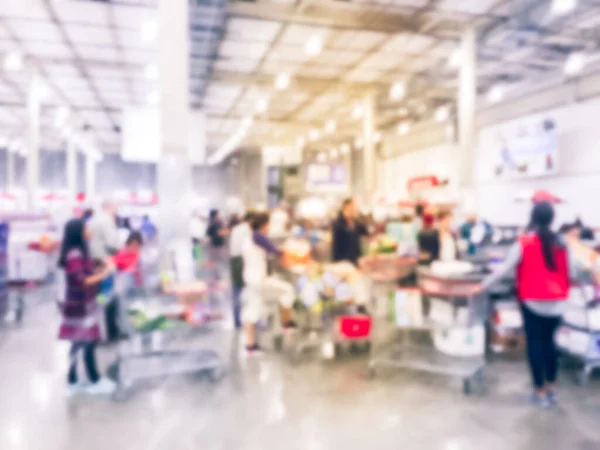 Imagem filtrada fundo desfocado por muito tempo diversas pessoas em fila no balcão de check-out da loja por atacado — Fotografia de Stock