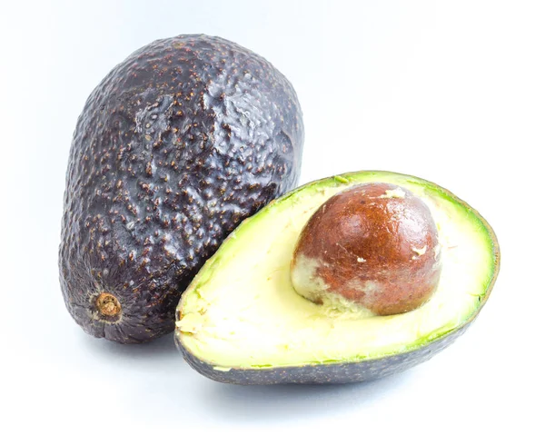 Estudio realizado con una sola fruta y medio corte de aguacates maduros aislados en blanco — Foto de Stock