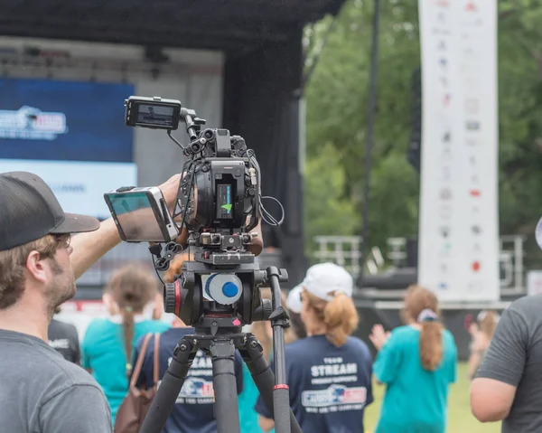 Video operator wear cap operating video recorder at live event in Dallas, Texas