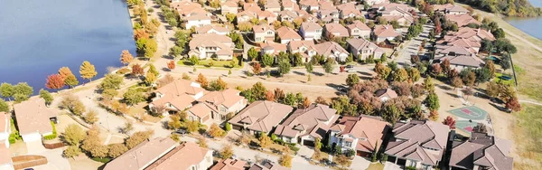 Panoramic aerial view new construction lakeside suburban house bright autumn orange color Dallas