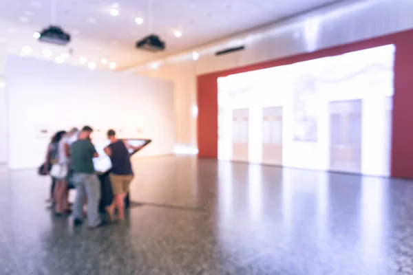 Blurry background people looking at fine art display at museum in America — Stock Photo, Image