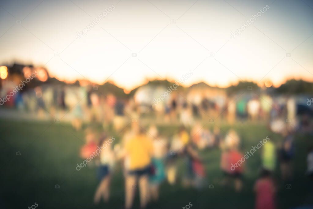 Blurry background crowded family members at summer event on park grass lawn near Dallas