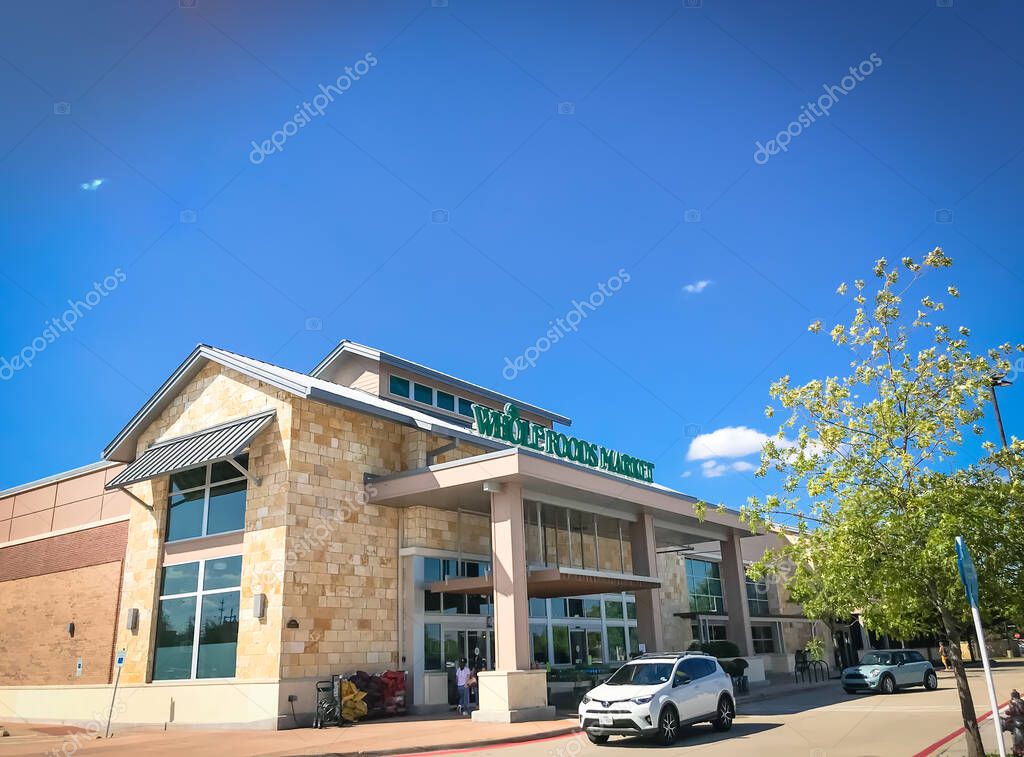 HIGHLAND VILLAGE, TX, US-OCT 2, 2019: Car driving by Whole Foods store entrance at Highland Village, a suburb of Dallas. This supermarket sells high quality and natural produces, hydrogenated free