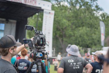Kameraman ve video kamera seti Dallas 'taki şehir parkında canlı kayıt yapıyor.