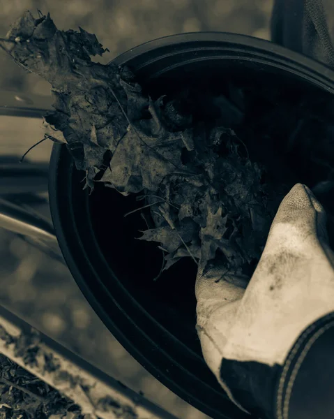 Imagen filtrada mano de cerca con guantes caer hojas secas y suciedad en el cubo de la limpieza de canalón — Foto de Stock