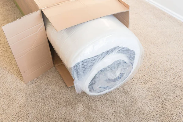 Close-up top view roll-packed spring mattresses unbox on carpet floor background — Stock Photo, Image