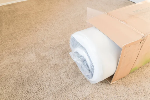 Close-up top view roll-packed spring mattresses unbox on carpet floor background — Stock Photo, Image