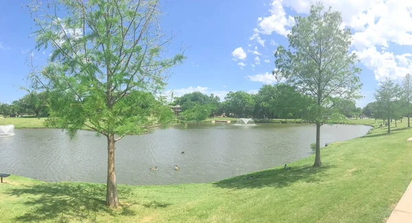 Vista panorâmica parque residencial com dupla via fontes flutuantes e banco de piquenique em Coppell, Texas, EUA — Fotografia de Stock