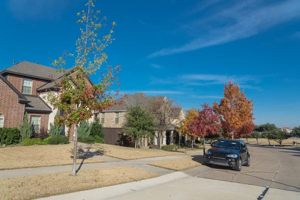 Entrada típica del porche delantero de las casas suburbanas nuevas con el coche estacionado en la calle colorida de la caída fuera de Dallas, Texas, los E.E.U.U. — Foto de Stock