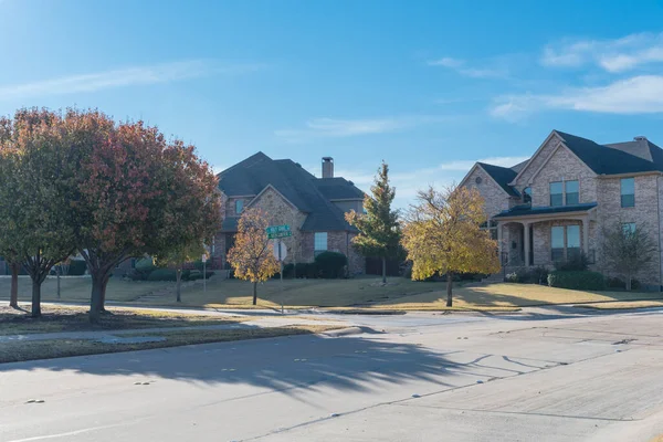 Muy nueva subdivisión de desarrollo con hilera de casas suburbanas y colorido follaje de otoño a lo largo de la acera cerca de Dallas, Texas, EE.UU. —  Fotos de Stock