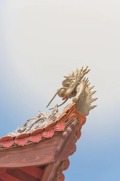 Vista verso l'alto tipico tetto cornice con la scultura testa di drago e tetto di piastrelle rosse in Vietnam — Foto Stock