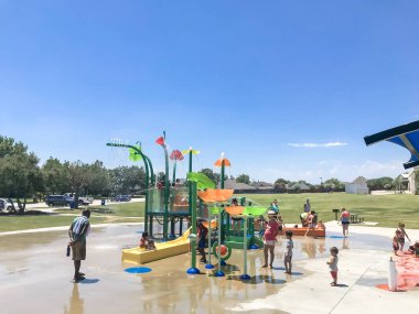 CoVID-19 sonrası Texas 'taki sıçrama parkında oynayan mutlu çokuluslu çocuklar ve ebeveynler