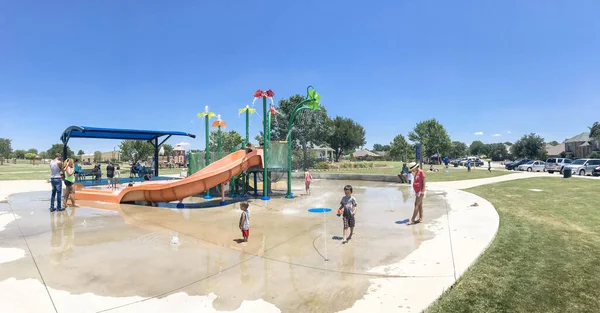 Panoramische multiculturele kinderen en ouders spelen in splash park in Texas na de COVID-19 pandemie — Stockfoto