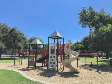 Dallas, Teksas, ABD şehir merkezinde büyük ağaçlarla çevrili halk parkındaki şehir çocuk parkı.